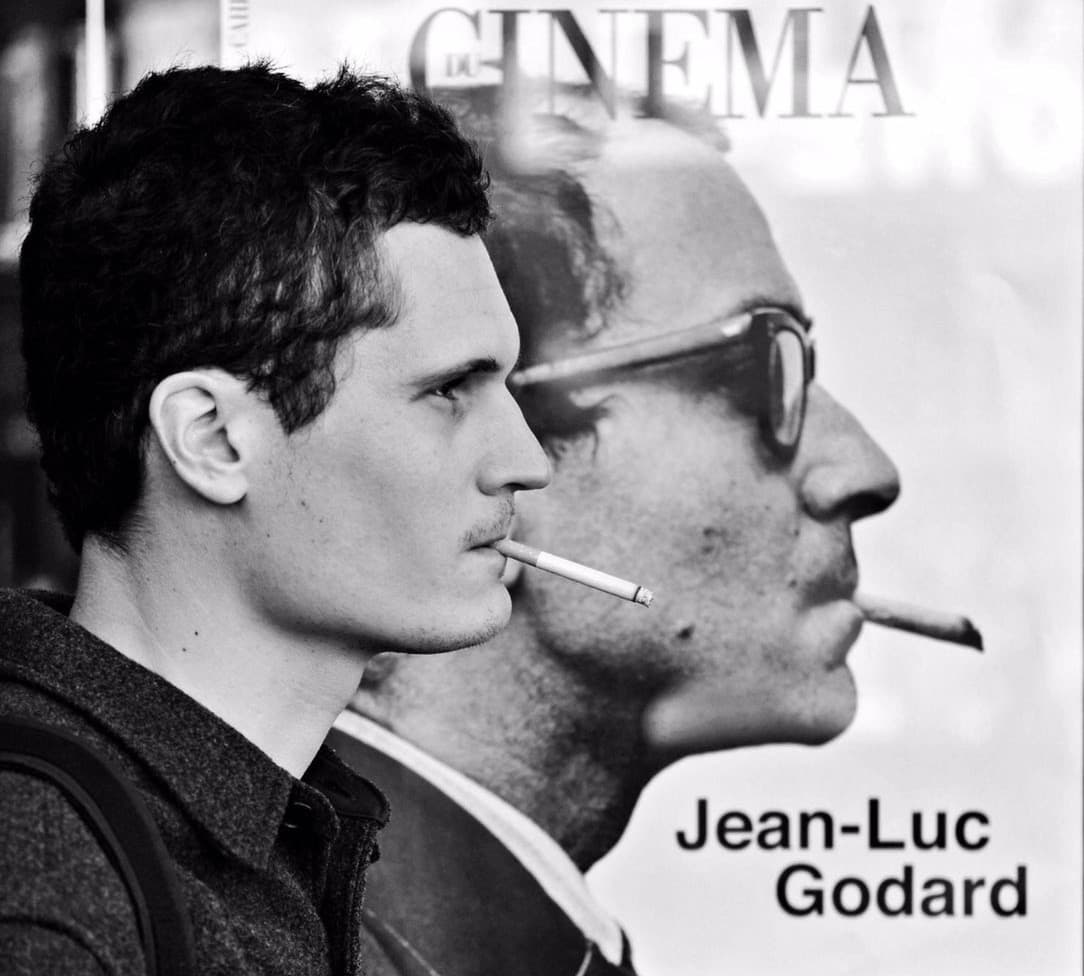 This is a picture of me, smoking a cigarette, in front of a newspaper stand ad for the magazine “Les Cahiers du Cinéma”, featuring a portrait of Jean-Luc Godard—smoking as well. The picture is in black and white, and was taken by a street photographer I didn’t know.